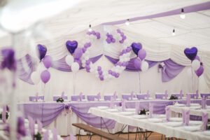 An event hall with white and purple balloons